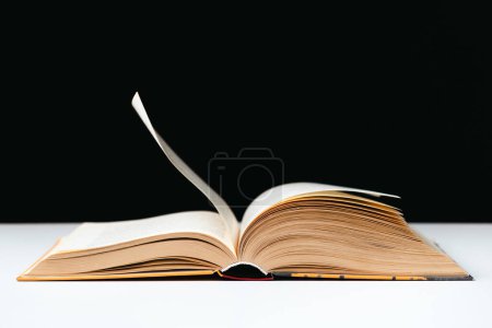 Photo for Pages of a thick book are turned on a white and black background, space for text - Royalty Free Image