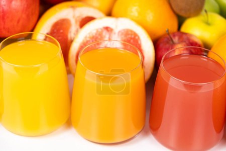Foto de Diferentes zumos de frutas en vasos sobre fondo blanco. - Imagen libre de derechos