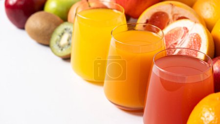Foto de Diferentes zumos de frutas en vasos sobre fondo blanco, espacio de copia para texto. - Imagen libre de derechos