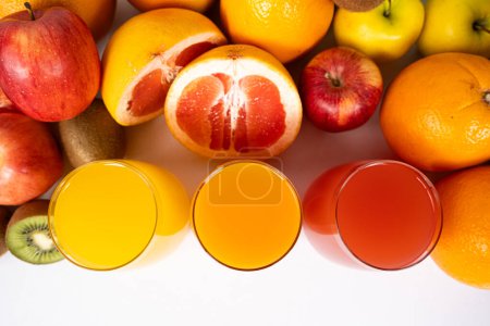 Foto de Diferentes zumos de frutas en vasos sobre fondo blanco. - Imagen libre de derechos