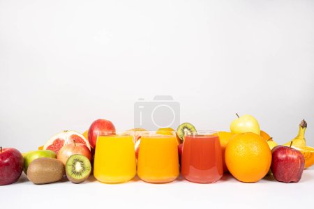 Foto de Diferentes zumos de frutas en vasos sobre fondo blanco con espacio para texto. - Imagen libre de derechos