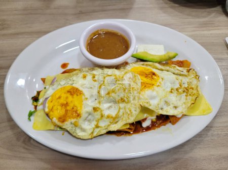 Delicious chilaquiles topped with sunny side up egg and savory sauce, breakfast