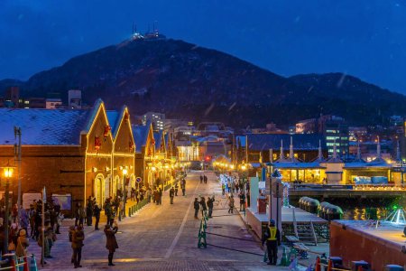 Photo for Cityscape of the historic red brick warehouses and Mount Hakodate  at twilight in Hakodate, Hokkaido Japan in winter - Royalty Free Image