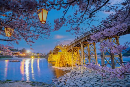 Téléchargez les photos : Pont Kintaikyo à Iwakuni, Japon au coucher du soleil avec des fleurs de cerisier - en image libre de droit