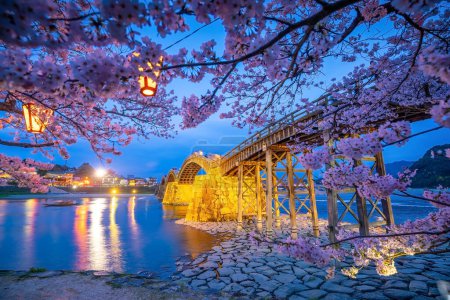 Téléchargez les photos : Pont Kintaikyo à Iwakuni, Japon au coucher du soleil avec des fleurs de cerisier - en image libre de droit