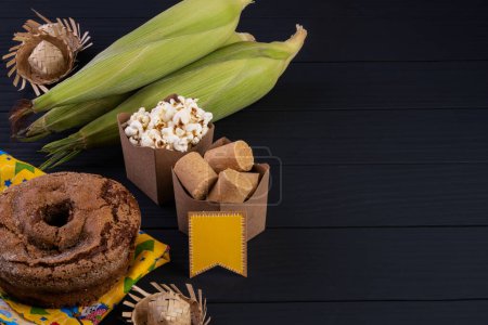 Foto de Decoraciones y alimentos de festa junina sobre mesa de madera negra - Imagen libre de derechos