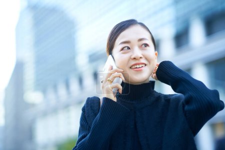 mujer asiática hablando en smartphone al aire libre