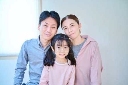 Photo for Commemorative photo of parents and their child in the room - Royalty Free Image