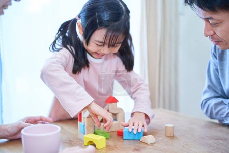 Photo for Parents and their child playing with building blocks - Royalty Free Image