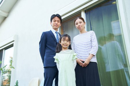 Téléchargez les photos : Photo commémorative de trois parents et de leur enfant chez eux - en image libre de droit