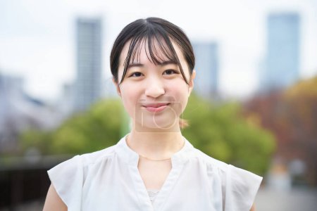 Téléchargez les photos : Asiatique jeune femme sourire et debout à l'extérieur - en image libre de droit