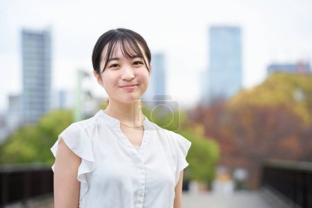 Foto de Asiático joven mujer sonriendo y de pie al aire libre - Imagen libre de derechos