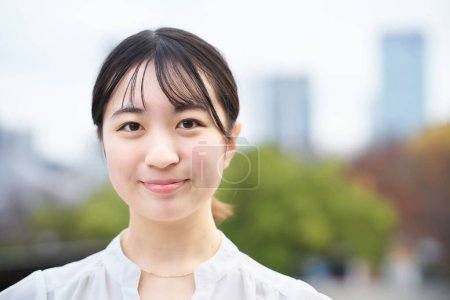 asian young woman smiling and standing outdoors