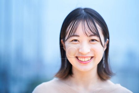 Foto de Asiático joven mujer sonriendo y de pie al aire libre - Imagen libre de derechos
