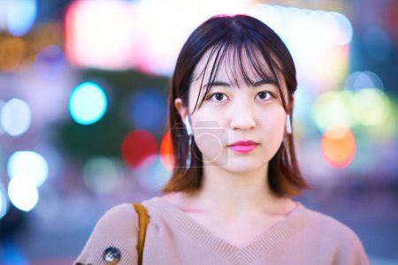 Téléchargez les photos : Asiatique jeune femme debout dans le centre-ville la nuit - en image libre de droit
