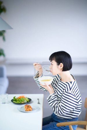 mujer joven comiendo en casa cenando