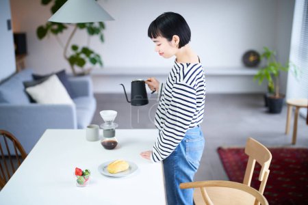 Foto de Mujer joven elaborando café en su habitación - Imagen libre de derechos