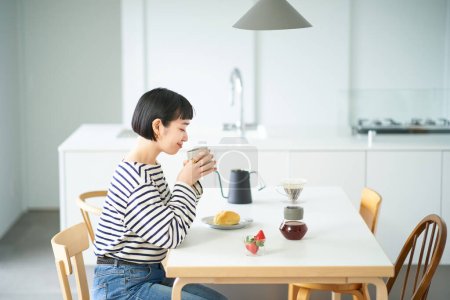 Photo for Young woman drinking coffee in the room - Royalty Free Image