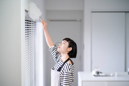 Foto de Asiático joven mujer limpieza la habitación - Imagen libre de derechos