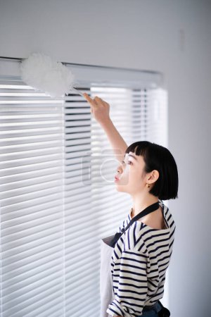 Téléchargez les photos : Asiatique jeune femme nettoyage la chambre - en image libre de droit