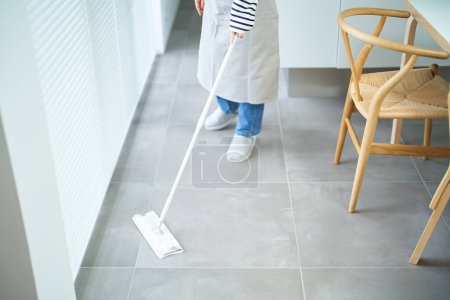 Téléchargez les photos : Asiatique jeune femme nettoyage le sol dans la chambre - en image libre de droit