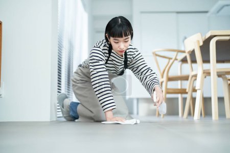 Foto de Mujer joven fregando el suelo en la habitación - Imagen libre de derechos