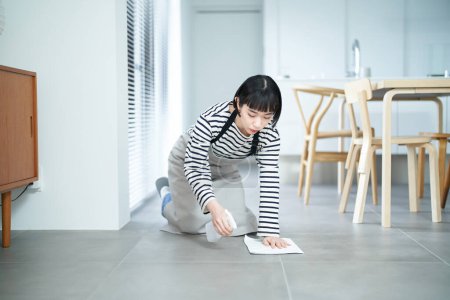 Photo for Young woman mopping the floor in the room - Royalty Free Image