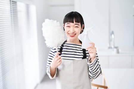 Foto de Mujer joven con herramientas de limpieza en la habitación - Imagen libre de derechos