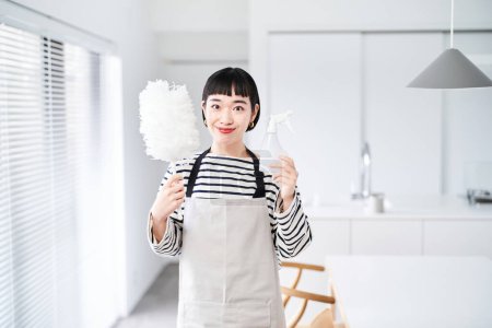 Téléchargez les photos : Jeune femme avec des outils de nettoyage dans la chambre - en image libre de droit