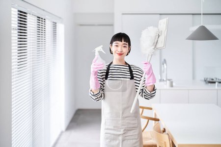 Photo for Young woman with cleaning tools in the room - Royalty Free Image