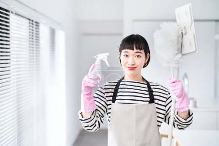 Photo for Young woman with cleaning tools in the room - Royalty Free Image