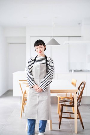 Photo for Asian young woman wearing apron in the room - Royalty Free Image