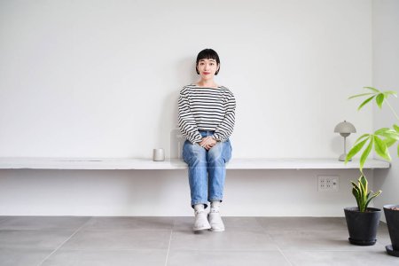 Foto de Una joven relajándose en una habitación con plantas de interior - Imagen libre de derechos