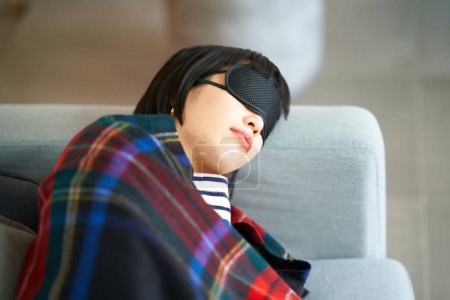 Photo for Young woman lying down with an eye mask in the room - Royalty Free Image
