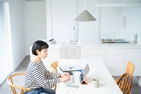 Foto de Mujer joven con gafas trabajando en la mesa en la habitación - Imagen libre de derechos