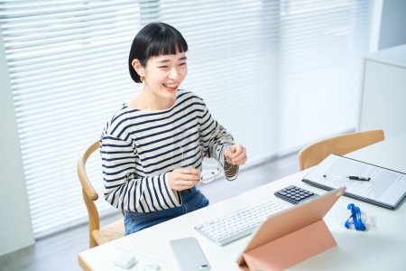 Téléchargez les photos : Une jeune femme portant des lunettes et travaillant à son bureau - en image libre de droit