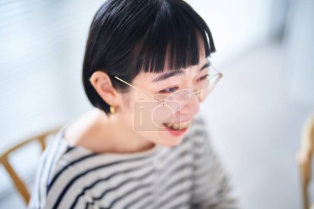 Foto de Una joven con gafas y trabajando en su escritorio - Imagen libre de derechos