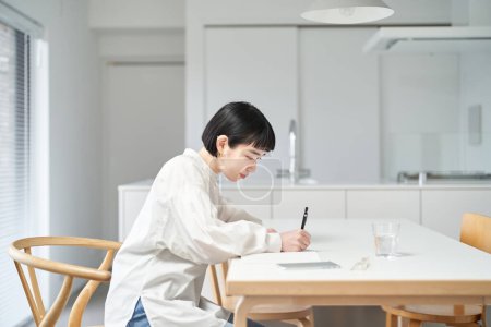 Mujer joven escribiendo en cuaderno en la habitación