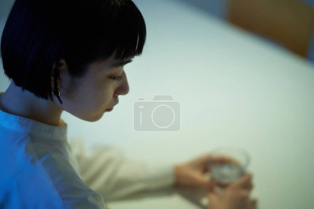 Foto de Mujer joven descansando en el cuarto oscuro - Imagen libre de derechos