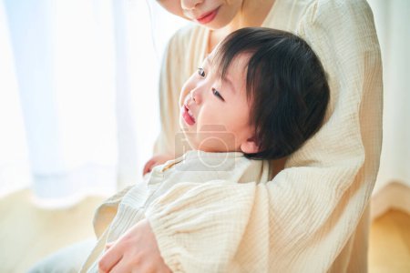 Foto de Joven madre sosteniendo a un bebé llorando en casa - Imagen libre de derechos
