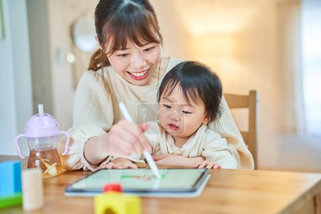 Téléchargez les photos : Mère et petit garçon jouant avec une tablette PC - en image libre de droit