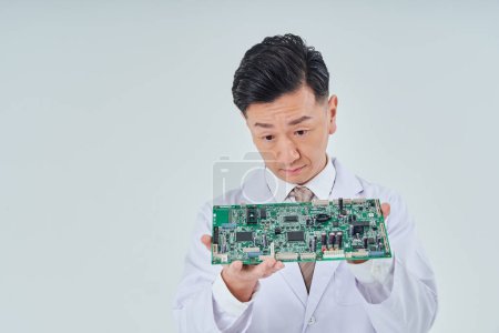 Photo for A man in a white coat with an electronic circuit and white background - Royalty Free Image