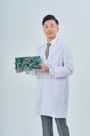 Foto de A man in a white coat with an electronic circuit and white background - Imagen libre de derechos