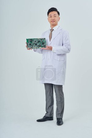 Photo for A man in a white coat with an electronic circuit and white background - Royalty Free Image