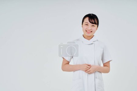 Foto de Mujer joven con un abrigo blanco en el interior y fondo blanco - Imagen libre de derechos