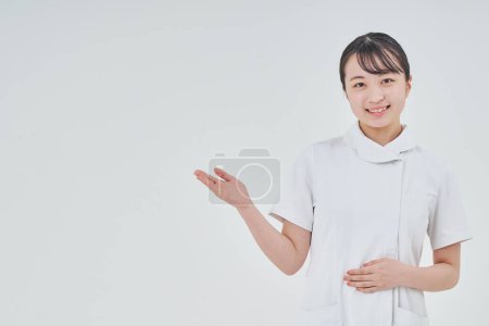 Foto de Mujer joven con un abrigo blanco en el interior y fondo blanco - Imagen libre de derechos