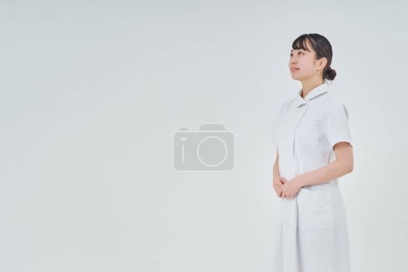Photo for Young woman wearing a white coat indoors and white background - Royalty Free Image