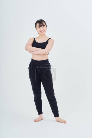 Photo for Young woman wearing sportswear indoors and white background - Royalty Free Image