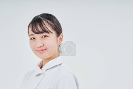 Téléchargez les photos : Jeune femme portant un manteau blanc à l'intérieur et fond blanc - en image libre de droit