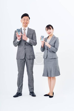 Téléchargez les photos : Homme et femme en costumes avec smartphones et fond blanc - en image libre de droit